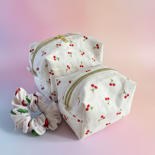 Cherry print makeup bag set with pink, purple, and peach brand colors